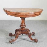 A Victorian burr walnut and marquetry folding card table, with a hinged half round top, on a