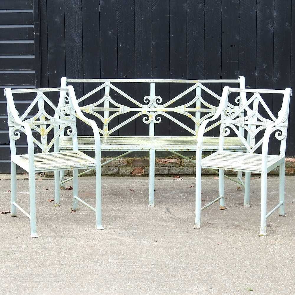 A Regency style cast iron garden set, with a strapwork back, comprising a bench and a pair of