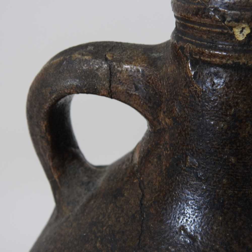 A 17th century German salt glazed stoneware bellarmine or Bartmann krug, of plain shape with a - Image 6 of 10