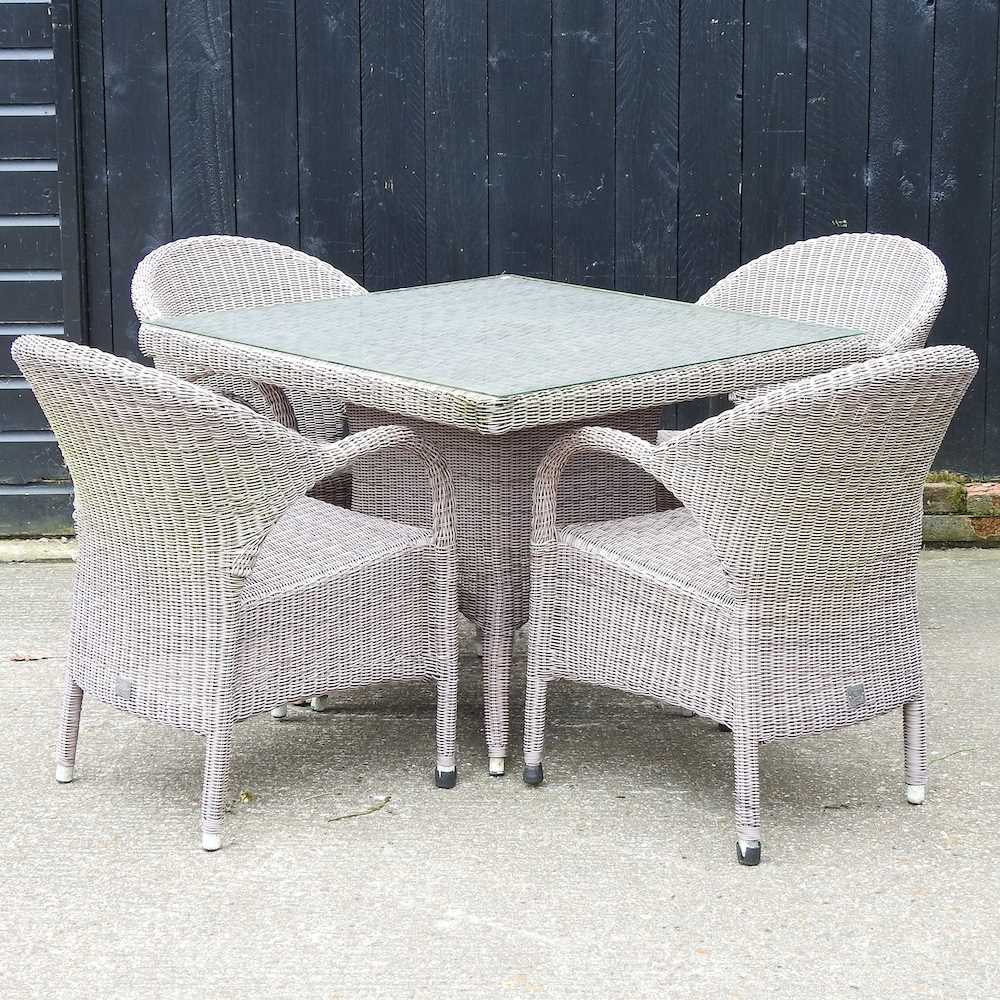 A Bridgman rattan garden table, with a glass top, together with a set of four matching armchairs