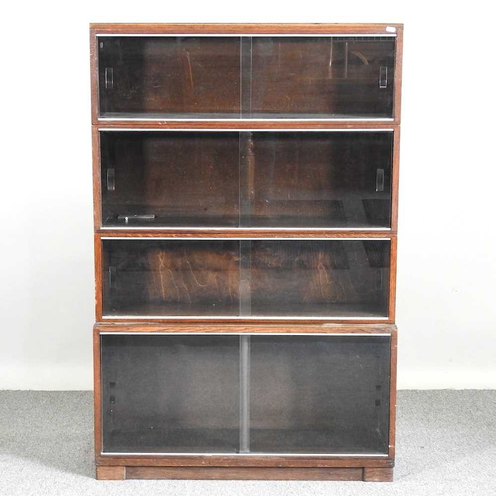 An early 20th century Minty glazed four tier sectional bookcase, enclosed by sliding glazed doors