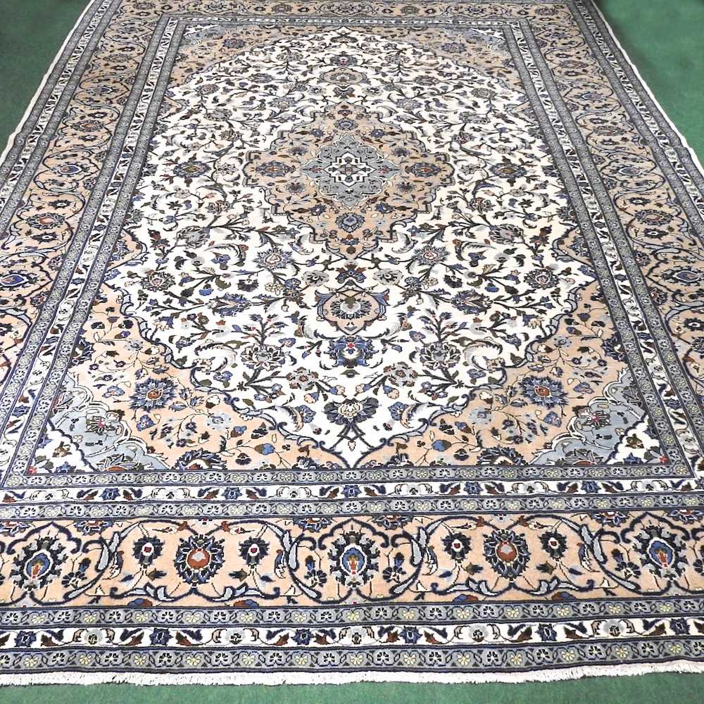 A large Persian Kashan woollen carpet, with all over scrolling foliate designs, on a cream ground,