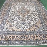 A large Persian Kashan woollen carpet, with all over scrolling foliate designs, on a cream ground,