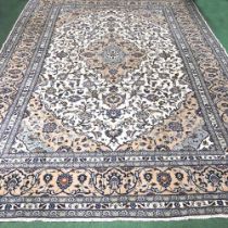 A large Persian Kashan woollen carpet, with all over scrolling foliate designs, on a cream ground,