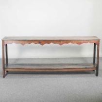 An 18th century Welsh dresser base, of narrow proportions, with an undulating frieze, on square