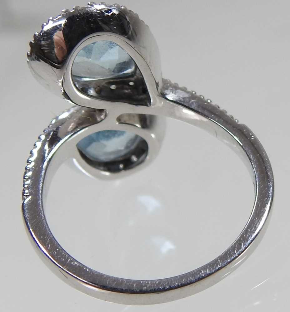 An 18 carat white gold and aquamarine cluster ring, of crossover design, set with two opposing heart - Image 2 of 5