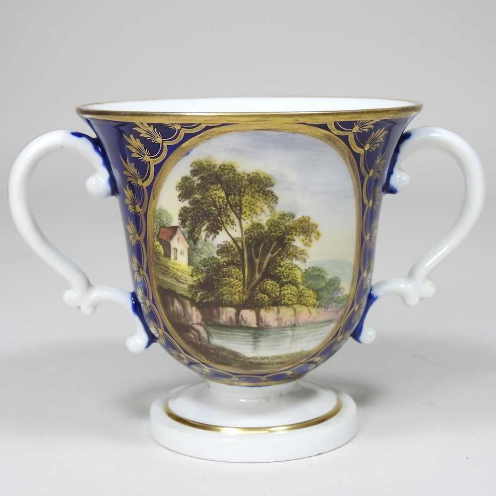 An early 19th century Derby porcelain twin handled cup, reserved with a river landscape, on a blue - Image 5 of 7