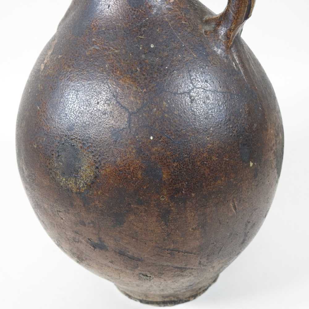 A 17th century German salt glazed stoneware bellarmine or Bartmann krug, of plain shape with a - Image 9 of 10