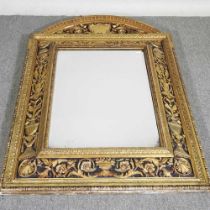 An ornate early 20th century continental carved wood and gilt cushion framed wall mirror, with a