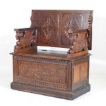 An early 20th century carved oak monk's bench, with griffin supports 92w x 50d x 82h cm