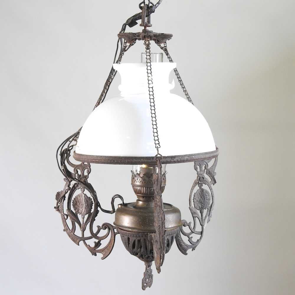 An early 20th century ceiling light, with an opaque white glass shade and scrolled supports, 47cm