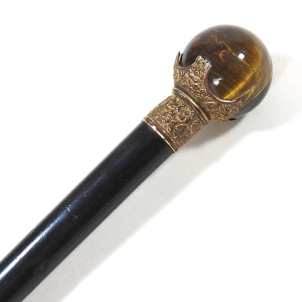 A late 19th/early 20th century ebonised walking cane, with a polished tiger's eye handle
