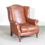A Laura Ashley brown leather upholstered wing armchair, on turned legs