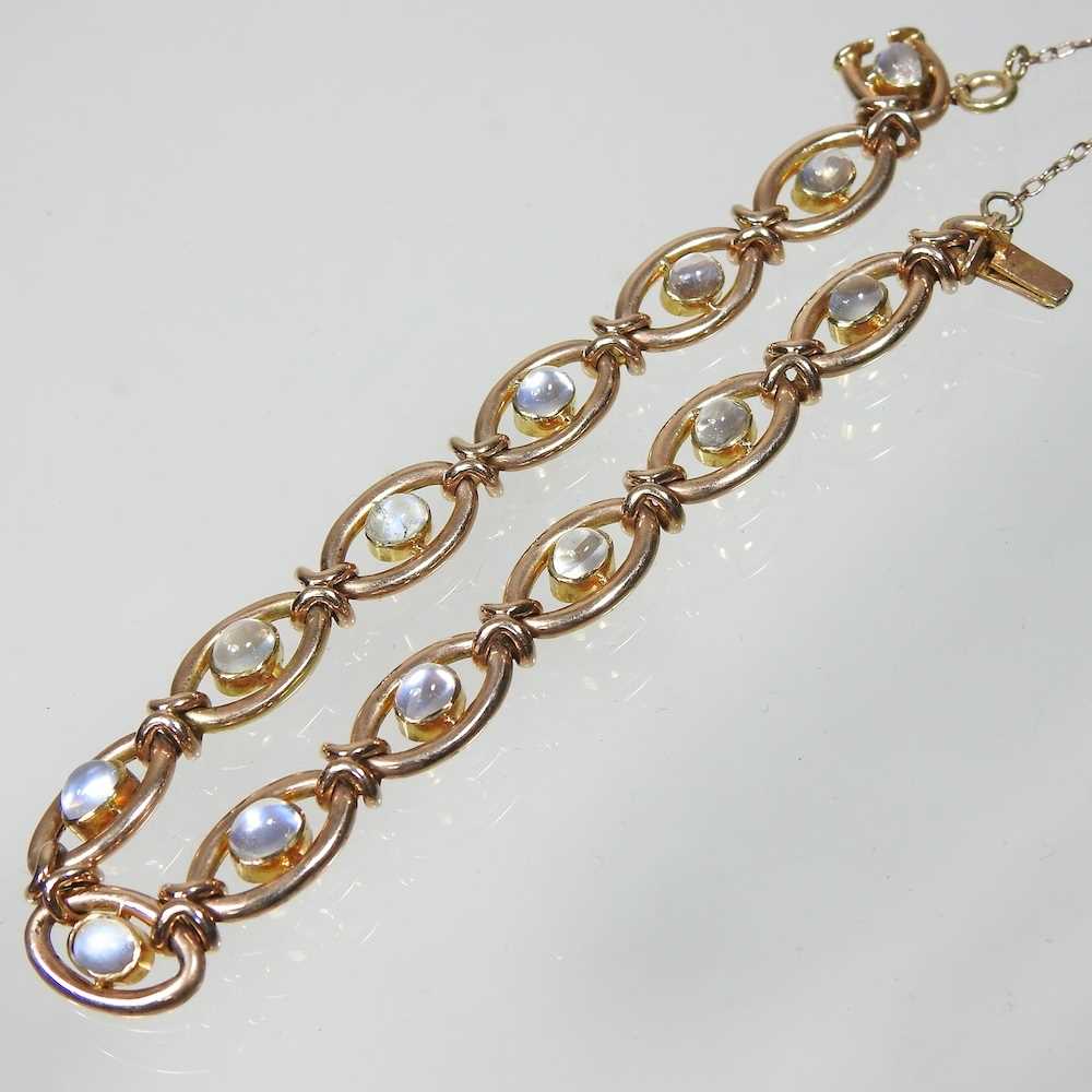 A 15 carat gold and moonstone fancy link bracelet, set with a single row of cabochon stones,