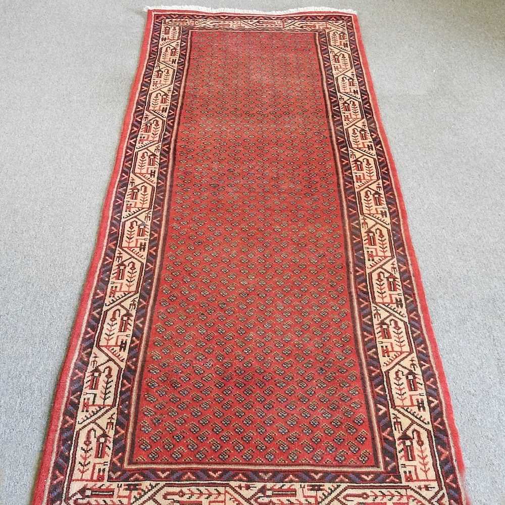 A Persian runner, with all over designs, within a cream border, 311 x 99cm