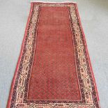 A Persian runner, with all over designs, within a cream border, 311 x 99cm