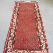 A Persian runner, with all over designs, within a cream border, 311 x 99cm