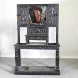 A 19th century heavily carved dark oak hall stand, with a mirrored back 111w x 42d x 172h cm