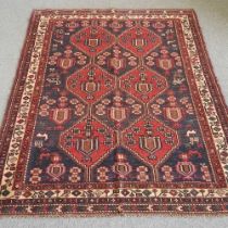 A Persian kilim, with six central medallions, on a dark blue ground, 210 x 155cm