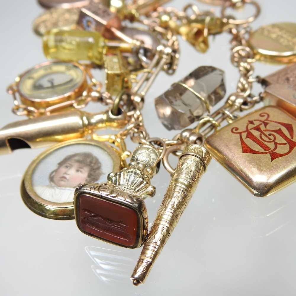 A gold charm bracelet, suspended with twenty-three various novelty charms, to include a sovereign - Image 10 of 12