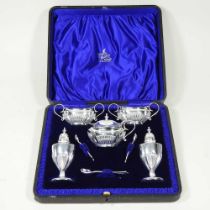 A silver plated condiment set, comprising a pair of salts, mustard, a pair of peppers and spoons, in