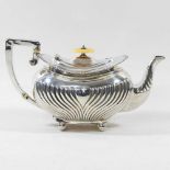 An Edwardian silver teapot, with a half gadrooned body and angular handle, on ball feet, Sheffield