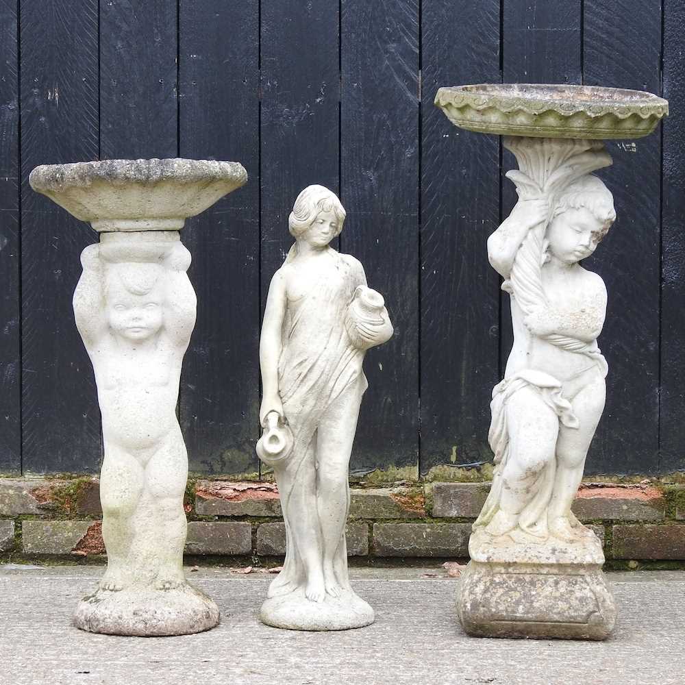 A cast stone figural bird bath, 84cm high, together with another smaller and a garden statue (3)