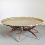 An unusually large Indian brass top occasional table, on a splayed base 117w x 44h cm