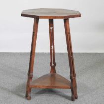 An Art Nouveau oak occasional table, with an octagonal top, on a splayed base 51w x 51d x 75h cm