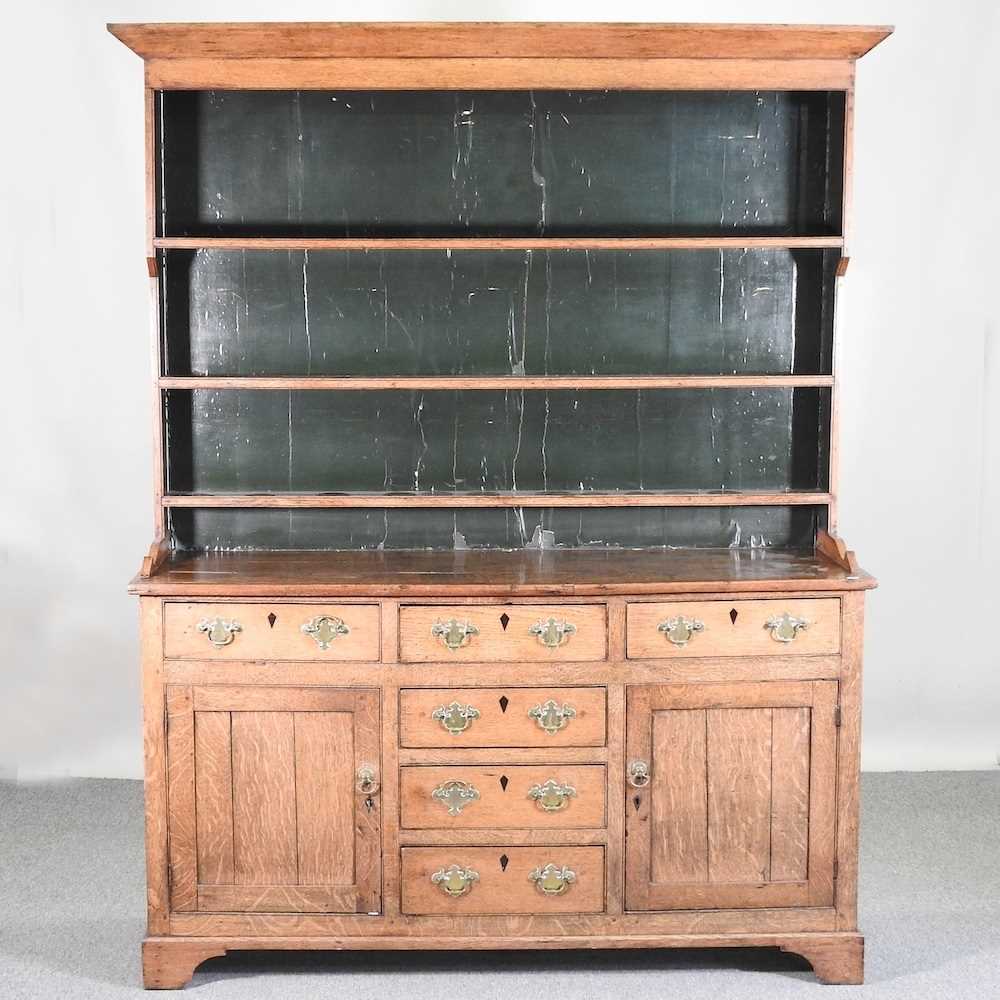 An 18th century Welsh oak dresser, having a boarded back, over an arrangement of short drawers and