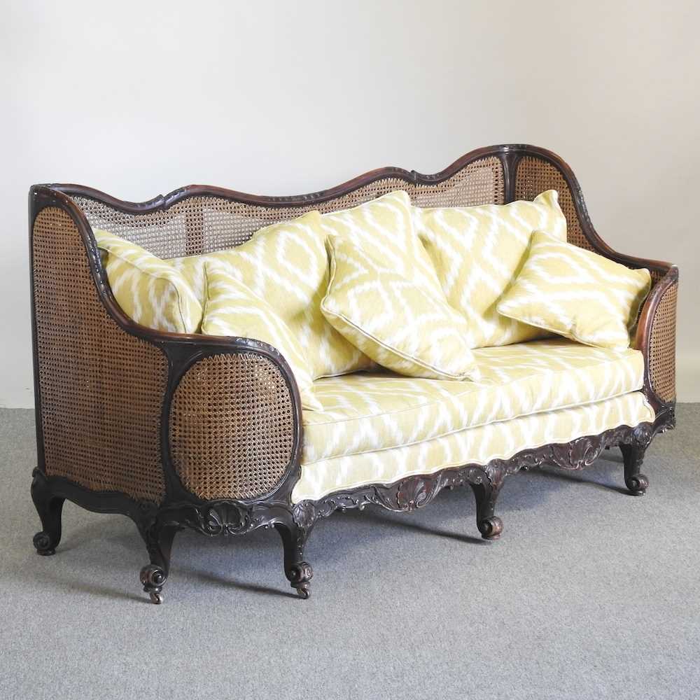 An early 20th century double cane bergere sofa, with yellow upholstery by Merryweather 186w x 72d