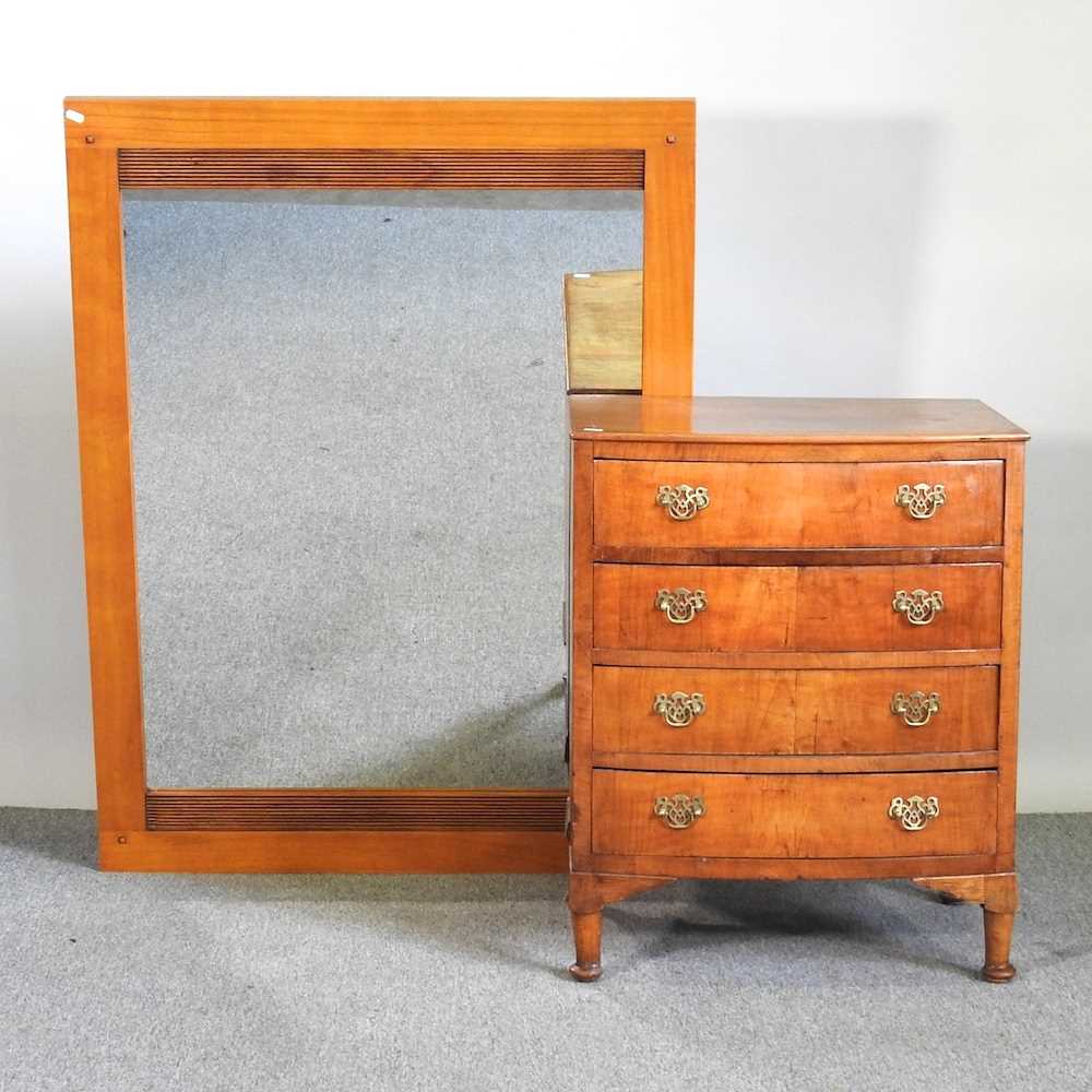 A small mid 20th century walnut bow front chest of drawers, together with a modern wall mirror, 90 x