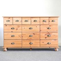 A pine merchant's chest, containing an arrangement of sixteen short drawers 132w x 40d x 82h cm