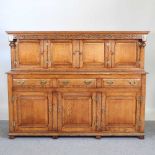 A good quality 17th century style light oak court cupboard, 20th century, having a carved frieze,