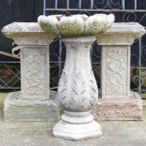 A pair of cast stone bird baths, 54cm high, together with another (3)