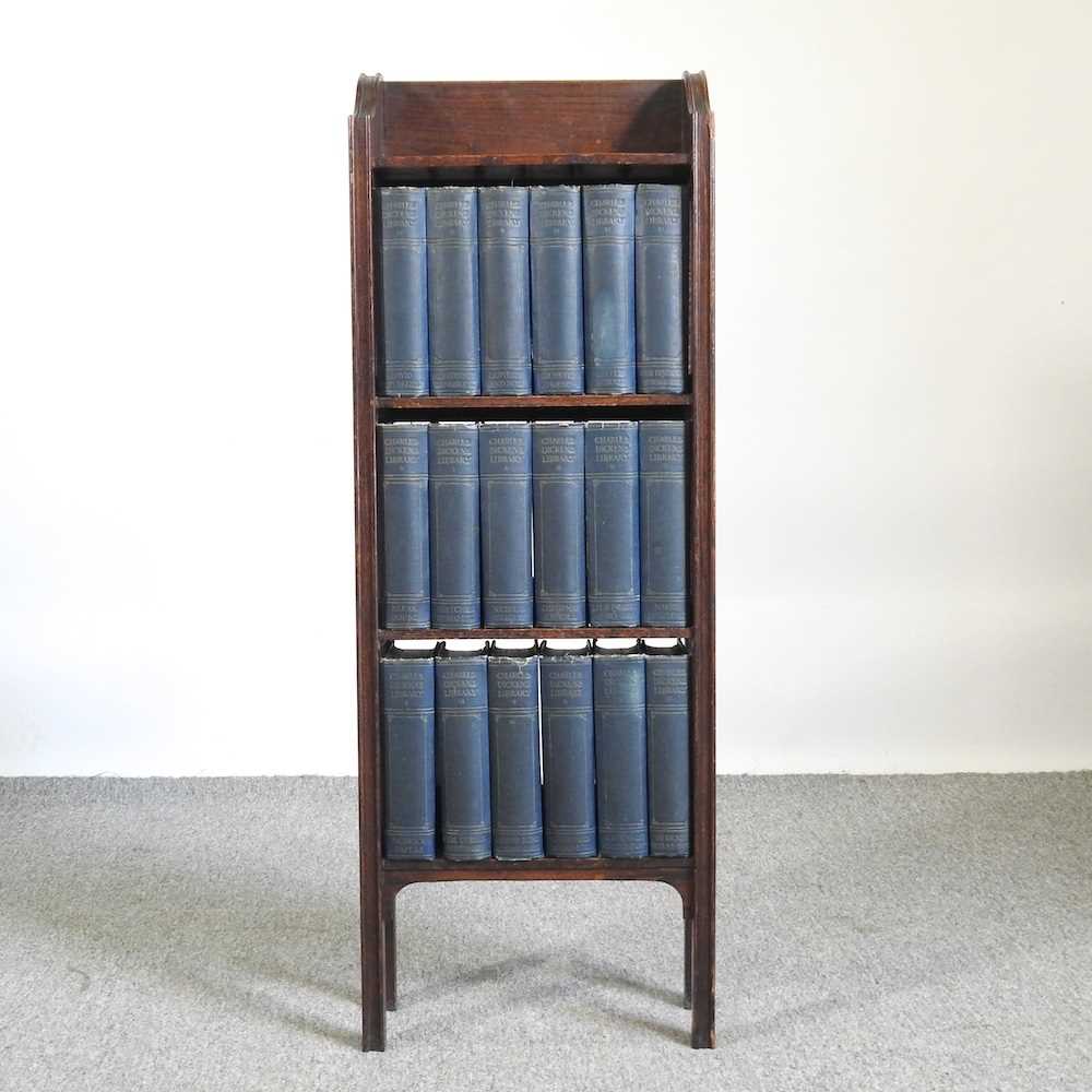 An early 20th century oak bookcase, containing a collection of Charles Dickens books 34w x 16d x 95h