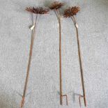 A set of three various rusted flower head plant supports, 152cm high