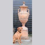 A very large terracotta stone garden urn and cover, of twin handled form, relief decorated with