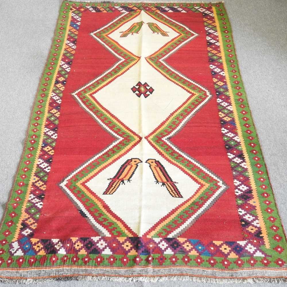 A kilim rug, with a cream central panel, decorated with birds, 290 x 145cm