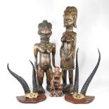 An African carved figure, 74cm high, together with two others and two pairs of mounted taxidermy