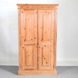 A modern pine cupboard, enclosed by panelled doors 96w x 28d x 168h cm