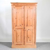 A modern pine cupboard, enclosed by panelled doors 96w x 28d x 168h cm