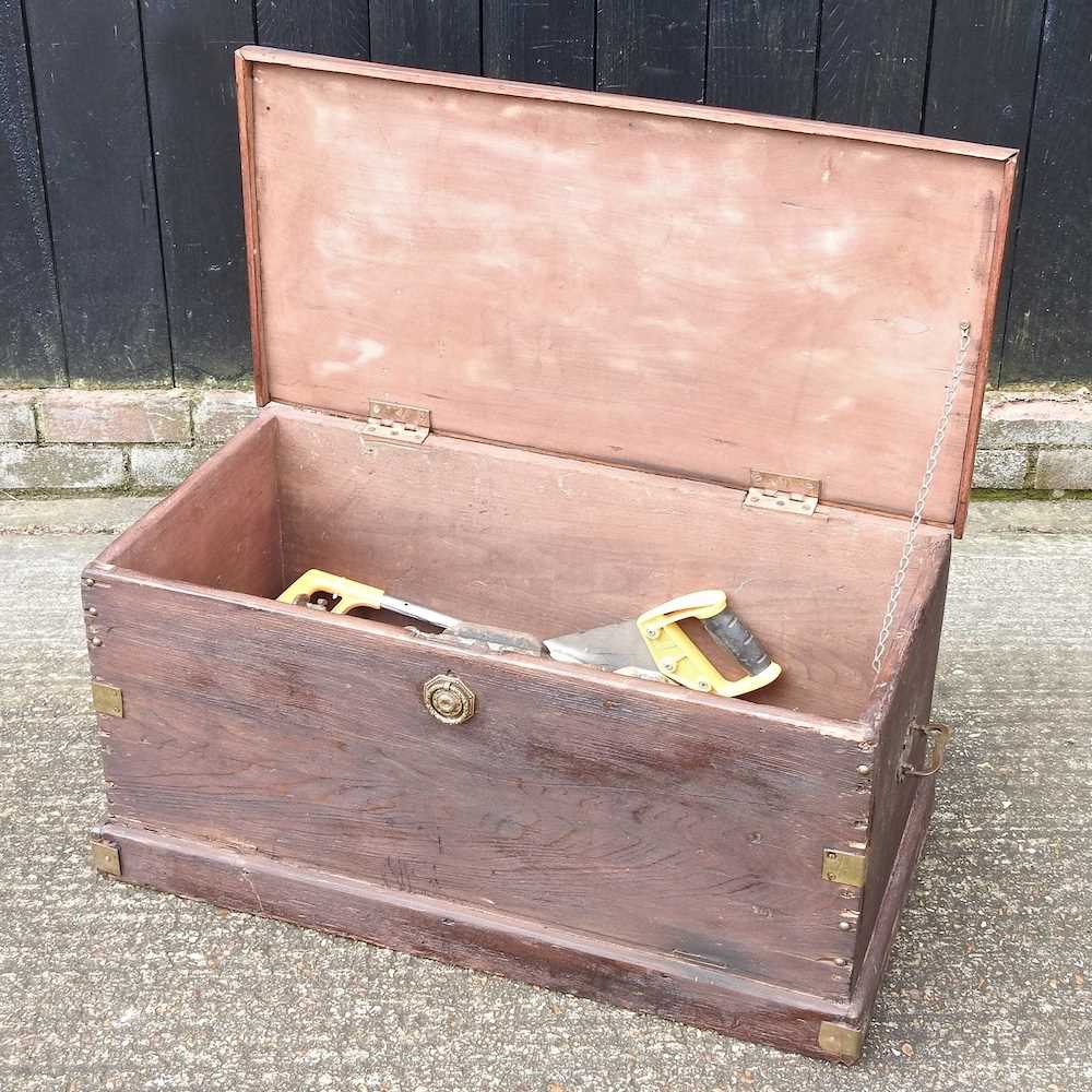 A wooden tool chest, 84cm wide, containing hand tools