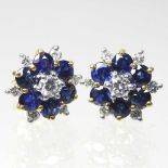 A pair of 18 carat gold, diamond and sapphire cluster earrings, of flowerhead design, each set