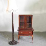 An early 20th century glazed cabinet on stand, together with a standard lamp and shade (2) 72w x 51d