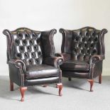 A pair of brown leather upholstered button back wing armchairs, on cabriole legs (2)