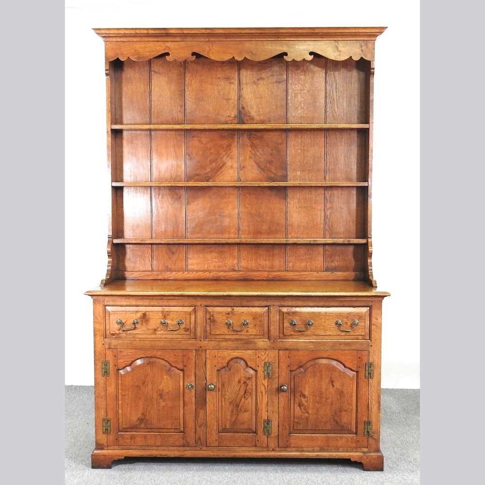 An 18th century style oak dresser, with a boarded back, on bracket feet 143w x 216h x 51d cm