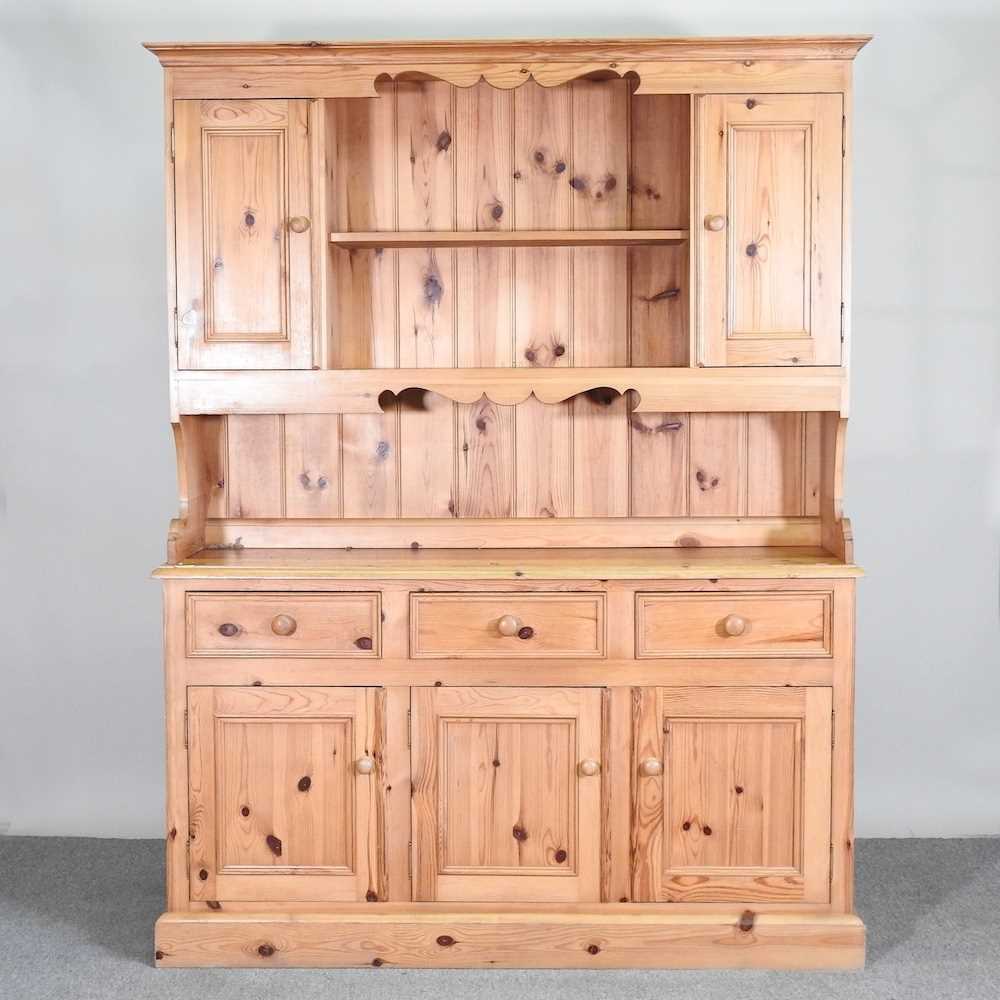 A modern pine dresser, with a boarded back, on a plinth base 152w x 45d x 200h cm
