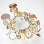 A gold charm bracelet, suspended with twenty-three various novelty charms, to include a sovereign