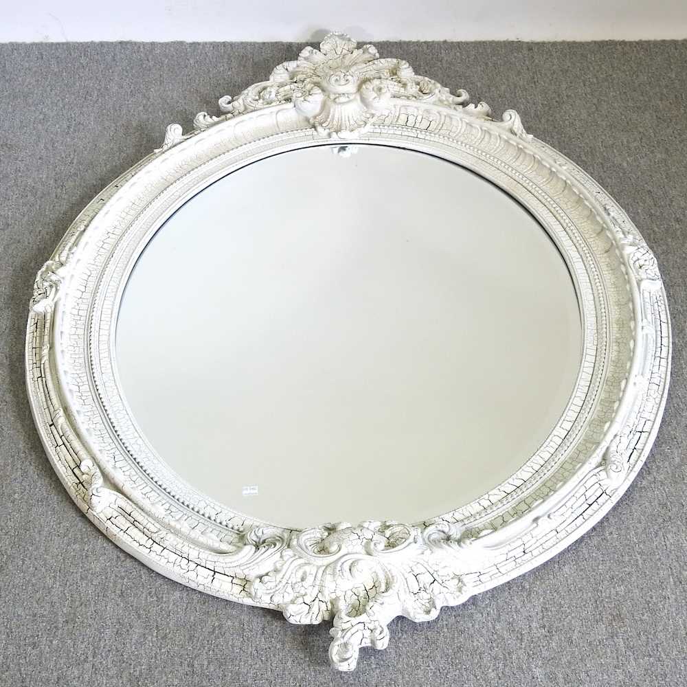 A large oval wall mirror, with a moulded white painted surround 102w x 152h cm